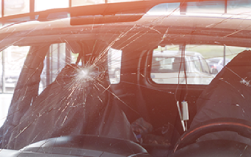 Car windshield with a large crack and spiderweb damage, likely from an impact.y